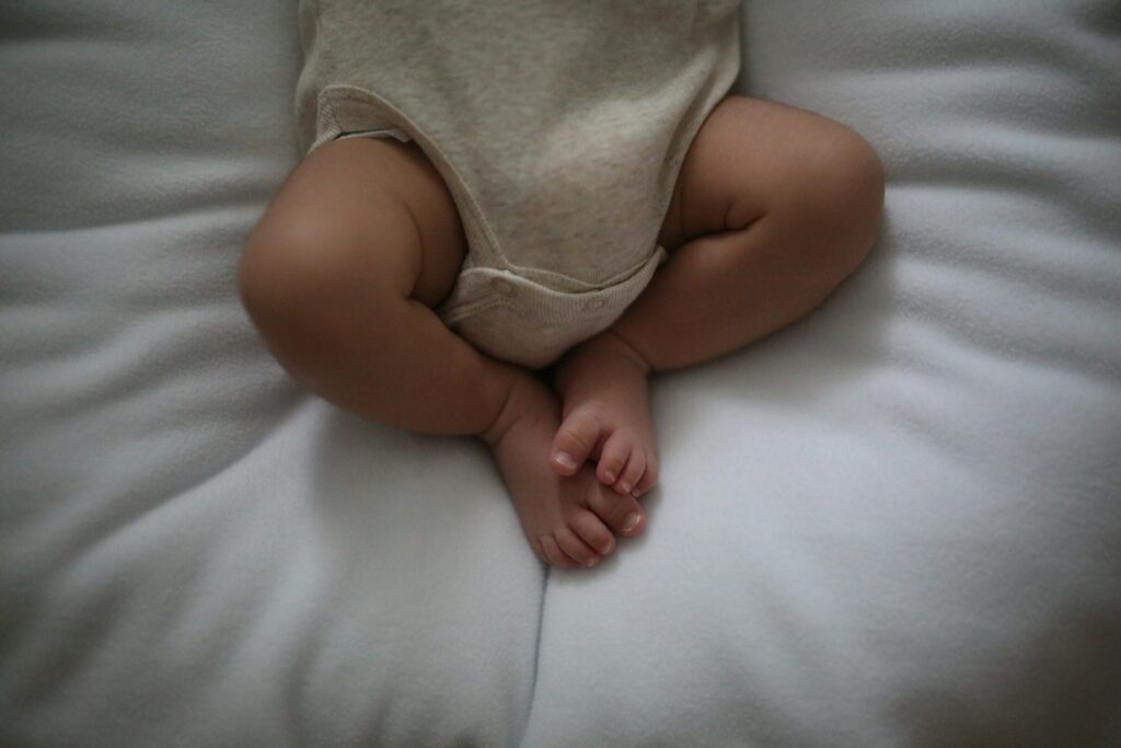 a baby laying on top of a white pillow