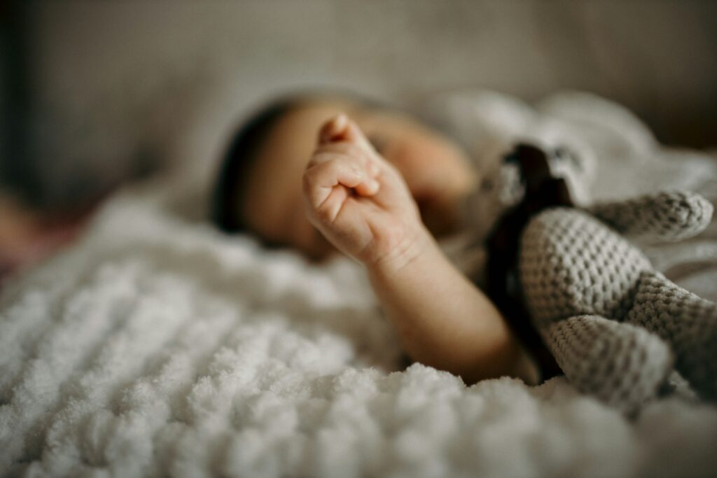 a close up of a baby laying on a blanket