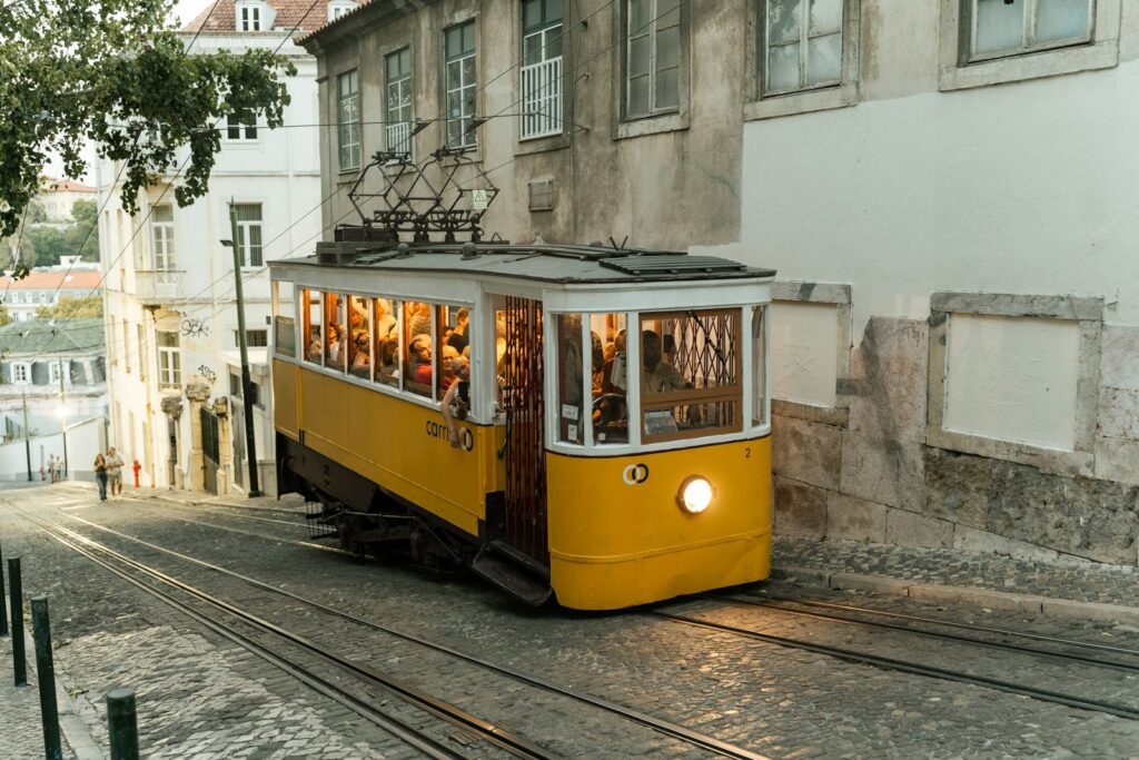 a yellow trolley car on a city street