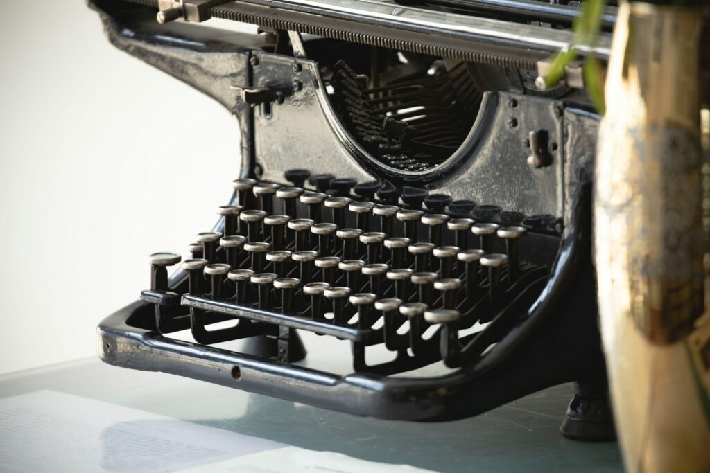 Close-up of an antique typewriter with a vase.