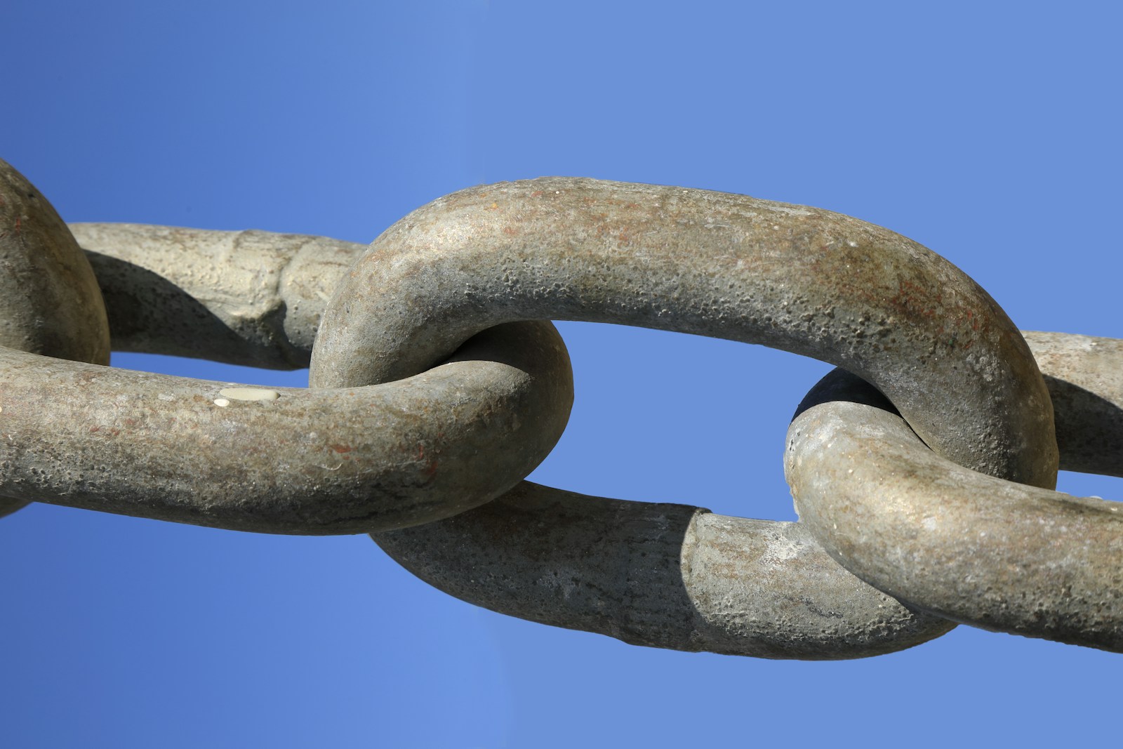 a close up of a chain with a blue sky in the background