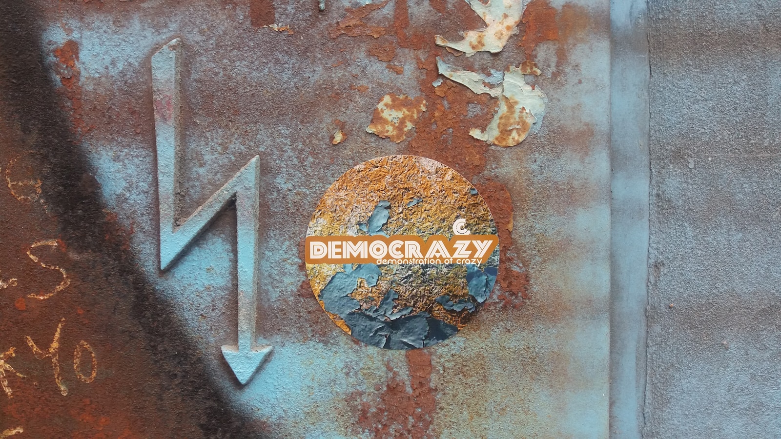 a rusted metal sign with the word democracy on it