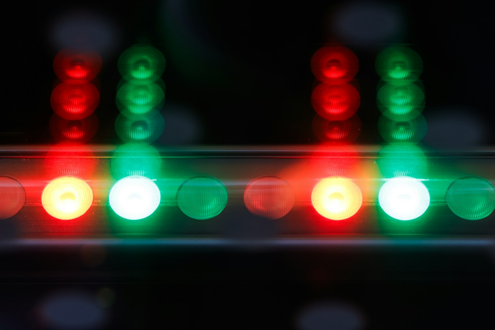 A close up of a traffic light that is red, green, and yellow