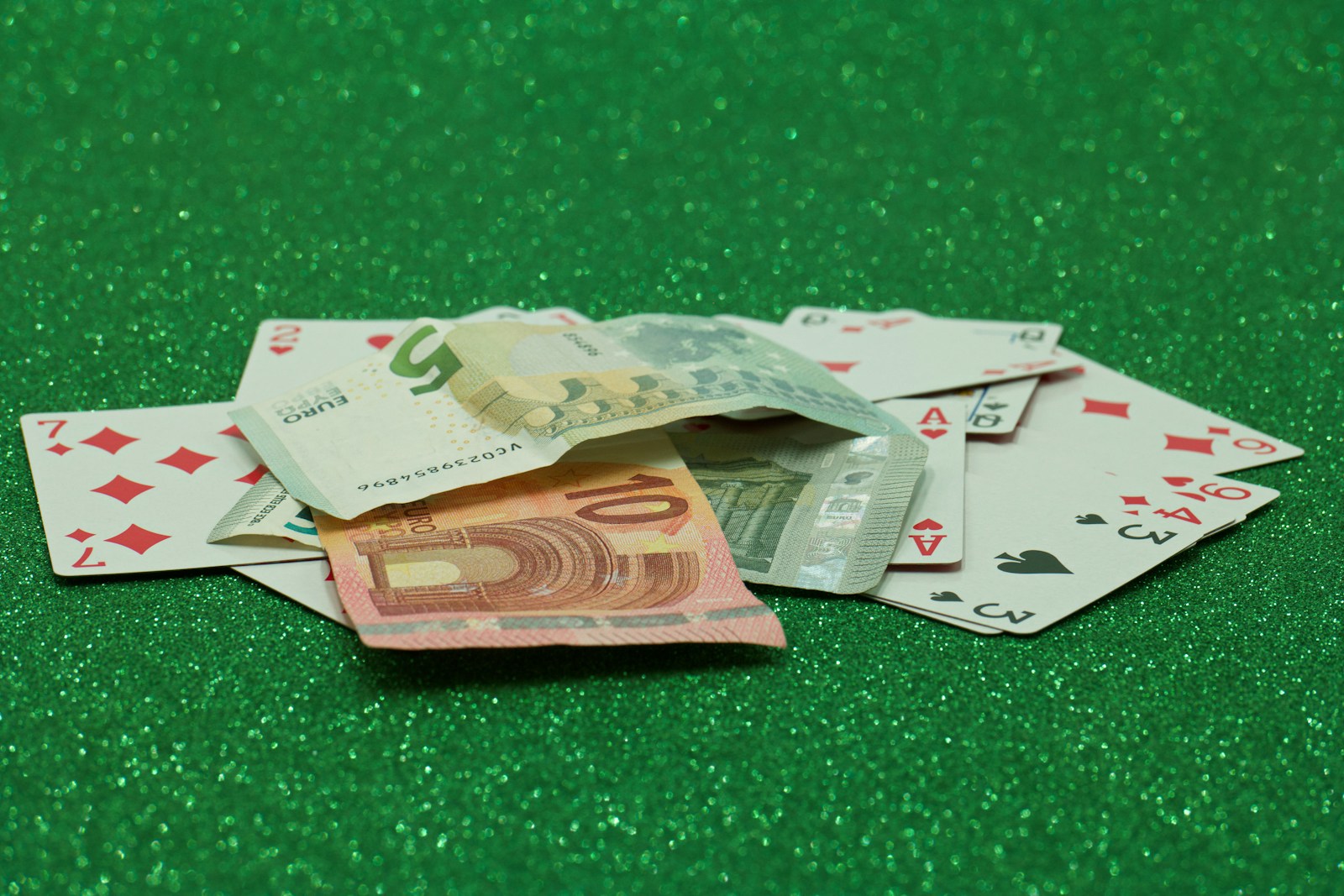 a pile of playing cards sitting on top of a green table
