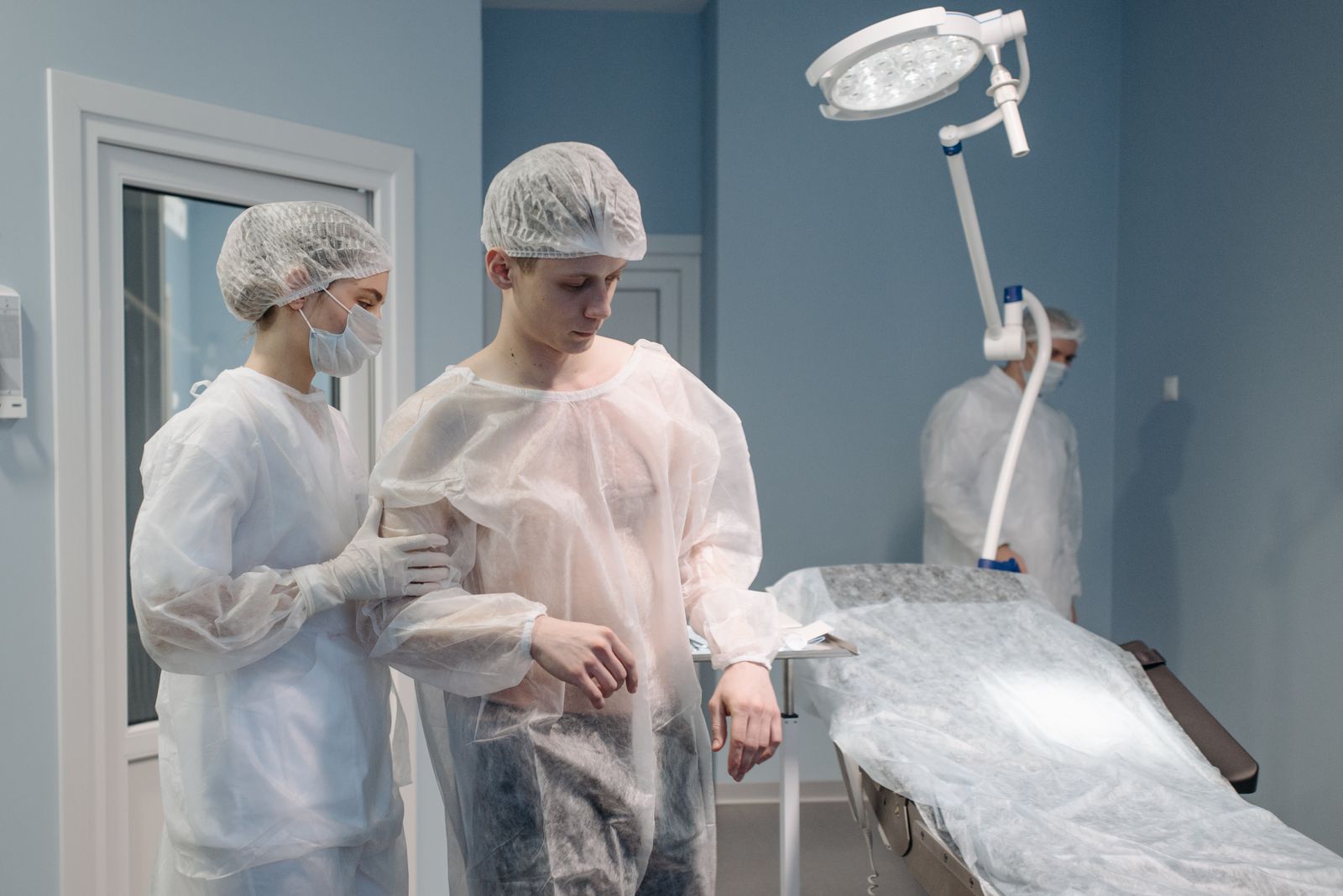 Doctors and nurses assist a patient in a modern operating room.