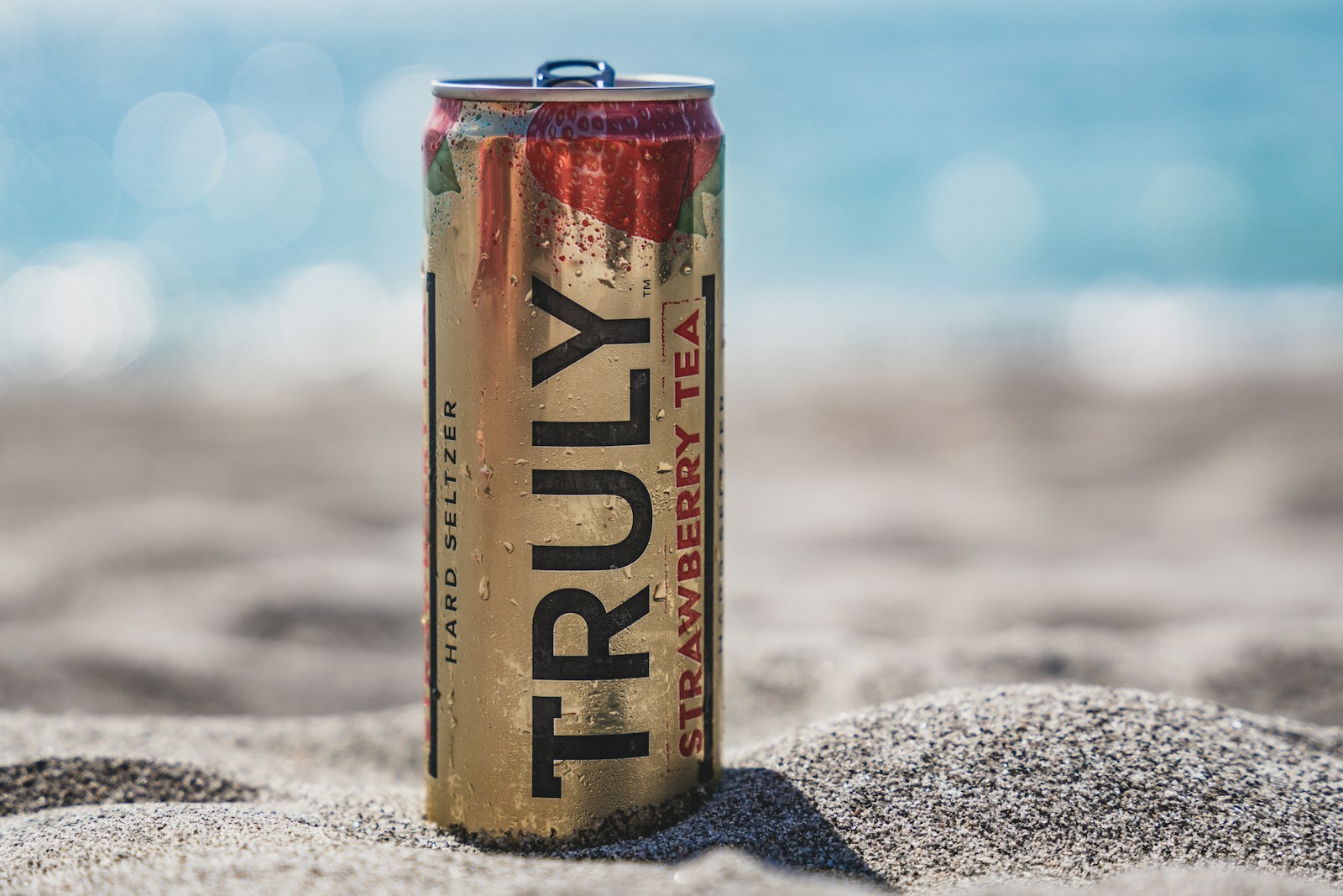 red and silver can on gray sand