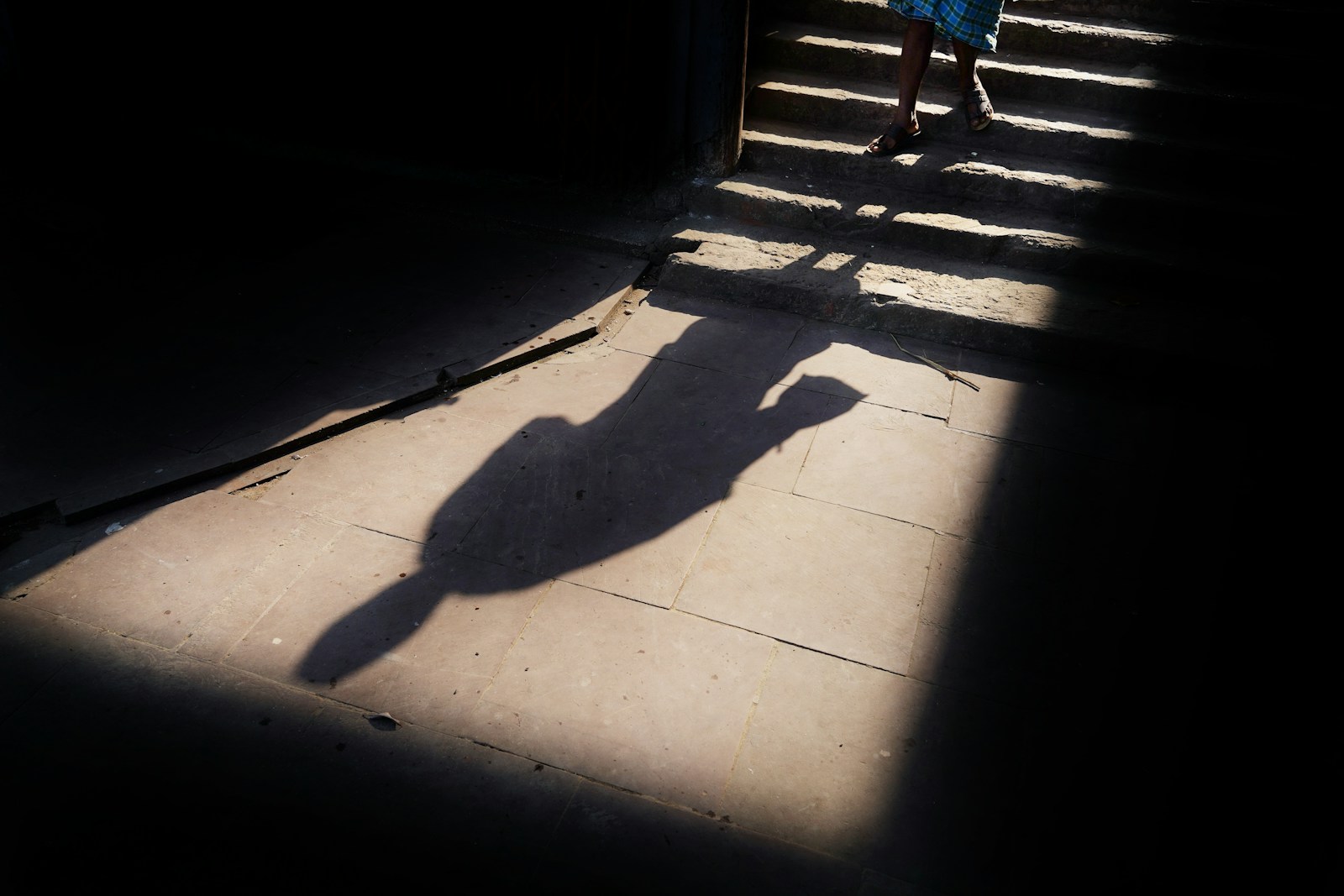 a person's shadow on a sidewalk